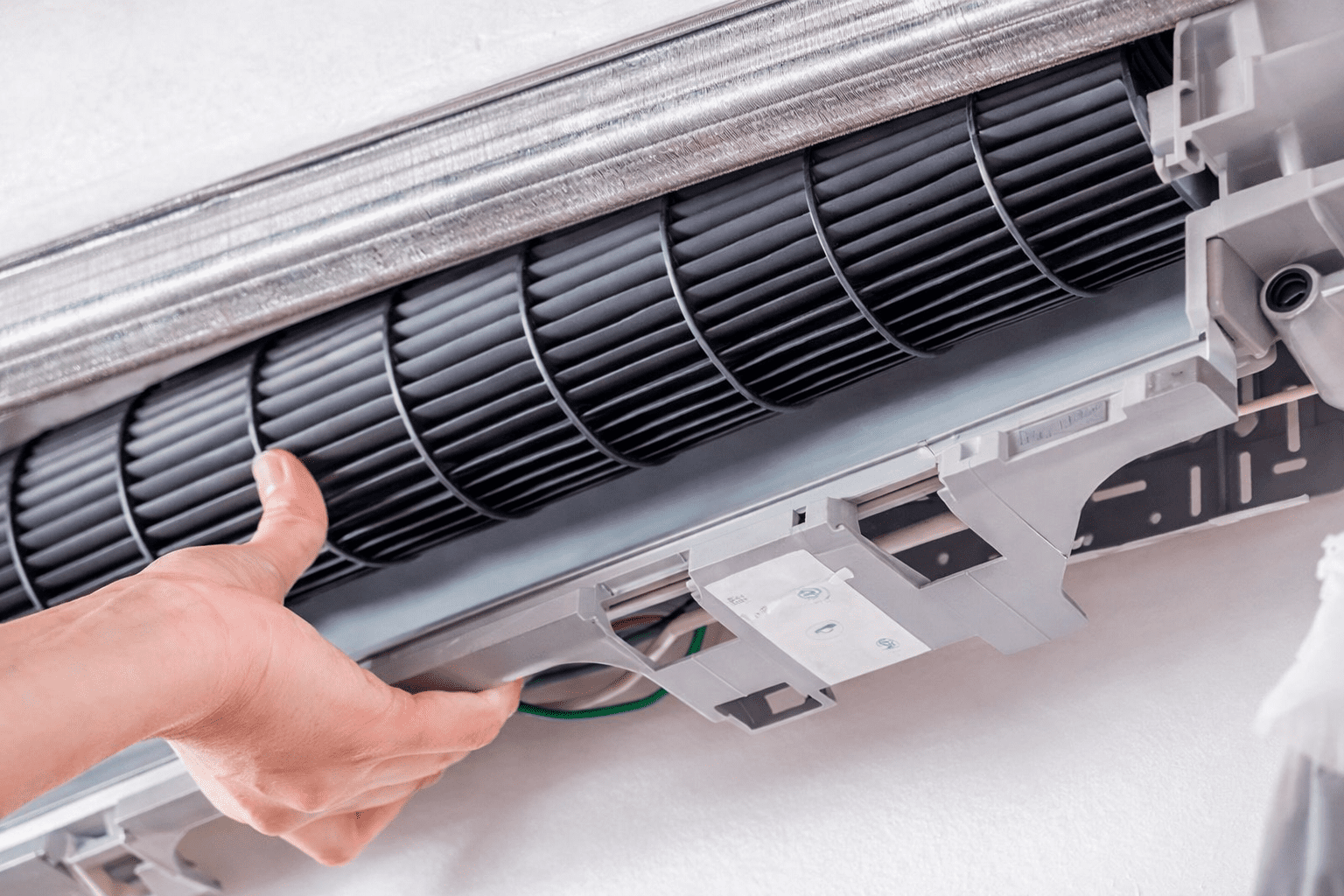 Técnico realizando Conserto de Ar Condicionado Residencial em São Paulo, ajustando componentes eletrônicos internos durante o reparo do equipamento.