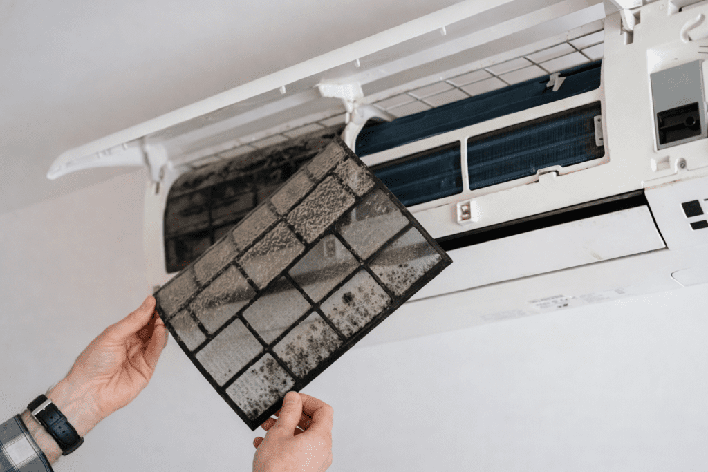 Técnico realizando Conserto de Ar Condicionado Comercial em São Paulo, ajustando componentes internos do sistema de climatização durante o reparo técnico.