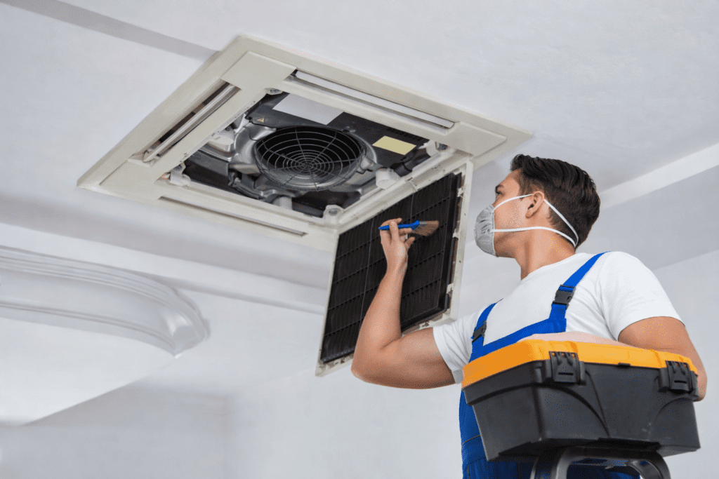 Técnico realizando Higienização de Ar Condicionado Comercial em São Paulo, efetuando a limpeza profunda dos componentes internos do sistema de climatização.