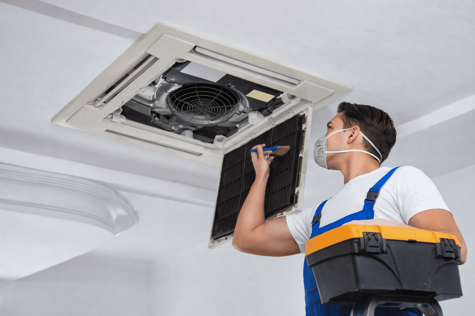 Técnico realizando Higienização de Ar Condicionado Comercial em São Paulo, efetuando a limpeza profunda dos componentes internos do sistema de climatização.