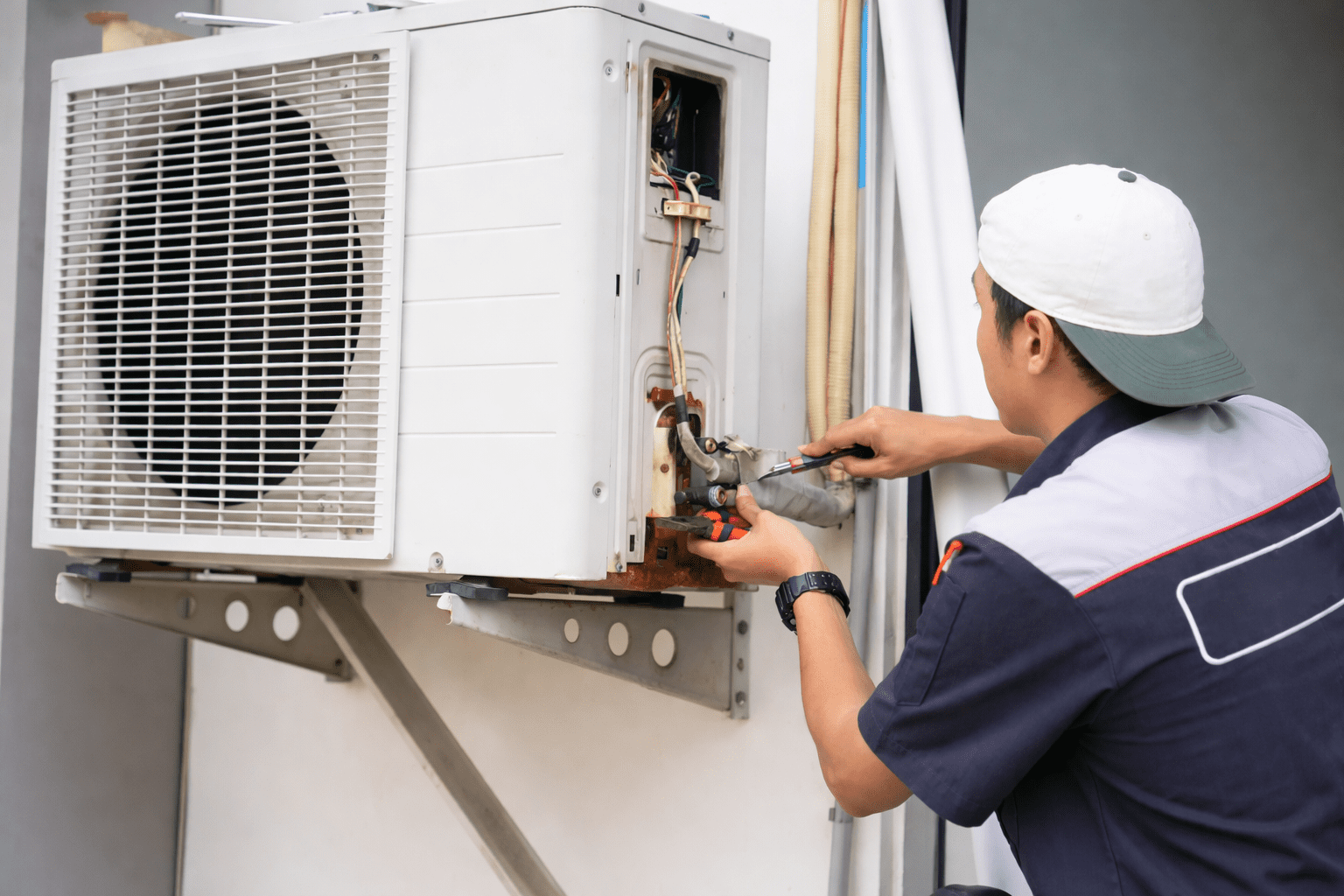 Técnico realizando Manutenção Corretiva de Ar Condicionado em São Paulo, limpando o evaporador interno com jato de água durante o reparo do equipamento.